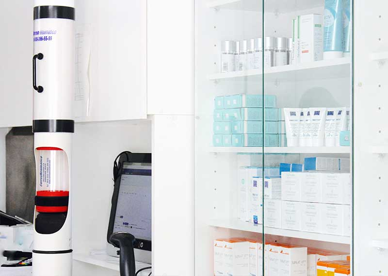 Estación de correo neumático instalada junto al área de atención de una farmacia